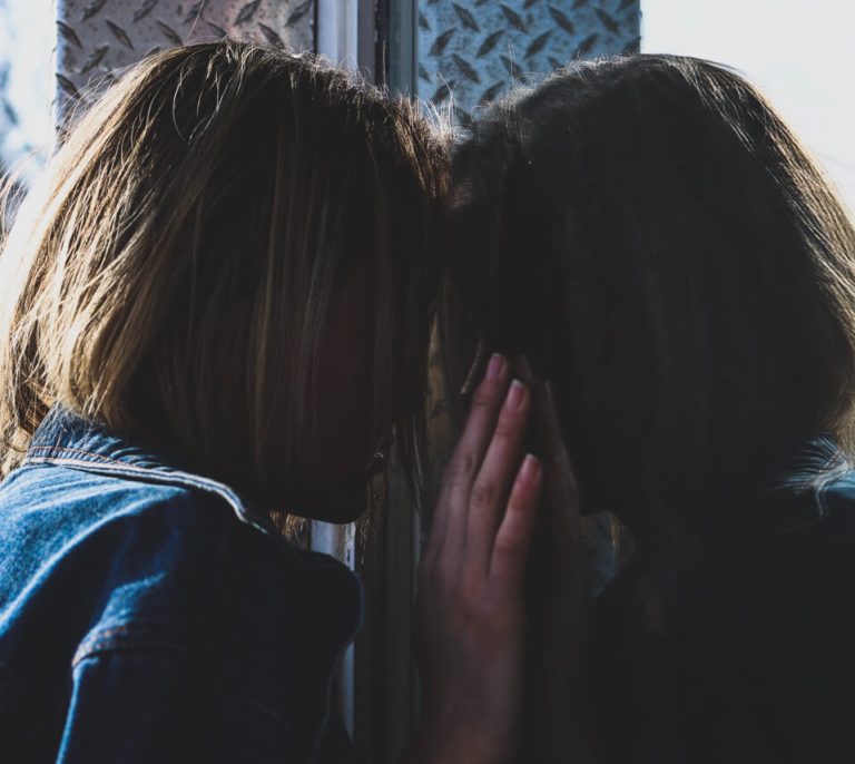 A couple of women touching their heads.